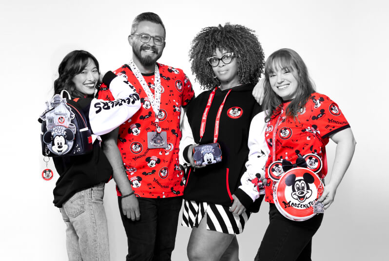 Black and white image with pops of red having 4 models showcase Loungefly Disney Mickey Mouseketeers Collection