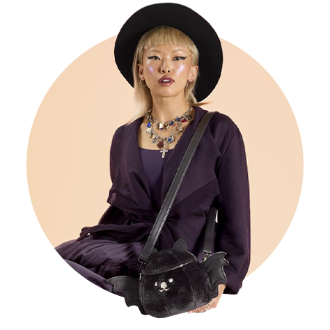 Circle-cropped photo with Tan background and model showcasing Loungefly Branded Halloween Bat Cosplay Crossbody Bag
